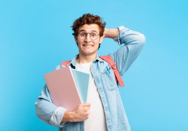 Genç öğrenci kendini stresli, endişeli, endişeli ya da korkmuş hissediyor. Elleri başının üstünde, hatayla panikliyor.