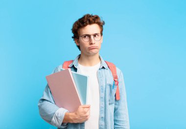 Genç öğrenci üzgün, üzgün ya da kızgın hissediyor ve olumsuz bir tavır takınıyor, anlaşmazlık içinde kaşlarını çatıyor.