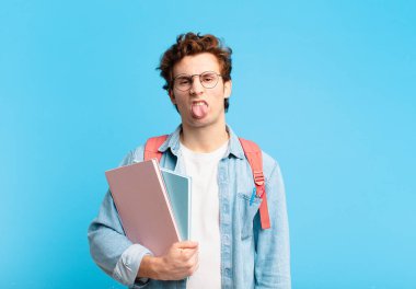 Genç öğrenci kendini iğrenç ve rahatsız hissediyor, dilini dışarı çıkarıyor, iğrenç ve iğrenç bir şeyden hoşlanmıyor.