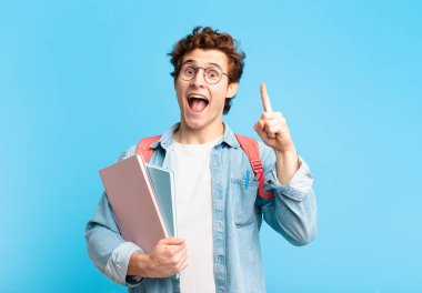 Genç öğrenci bir fikri fark ettikten sonra mutlu ve heyecanlı bir dahi gibi hissediyor, neşeli bir şekilde parmağını kaldırıyor, eureka!