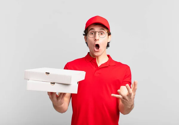 ピザは男の子に口を開けて驚きショックを与え驚くほど驚きを与えます — ストック写真