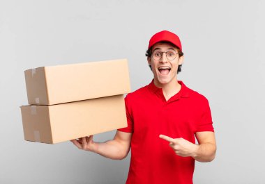 Paket teslimatçısı çocuk heyecanlı ve şaşırmış görünüyor.