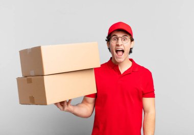 Paketçi çocuk agresif bir şekilde bağırıyor, sinirli, sinirli, öfkeli ya da sinirli görünüyor, bağırmıyor.