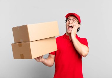 Paket teslimatçısı mutlu, heyecanlı ve şaşırmış hissediyor, iki eli yüzü yana bakıyor