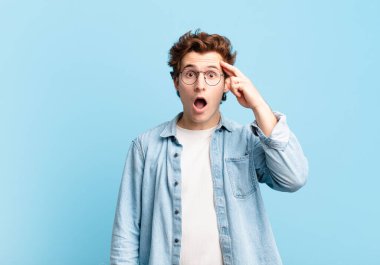 Genç yakışıklı çocuk şaşırmış, ağzı açık, şok olmuş, yeni bir düşünce, fikir ya da konsept keşfediyor.