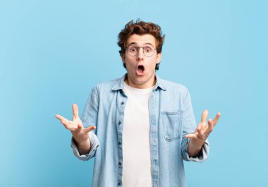 Genç yakışıklı çocuk şok olmuş ve şaşırmış, endişeli ve paniklemiş, stresli ve korkmuş bir bakışla
