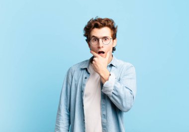 Ağzı ve gözleri açık, eli çenesinde genç ve yakışıklı bir çocuk. Hoş olmayan bir şok geçiriyor. Ne diyor?