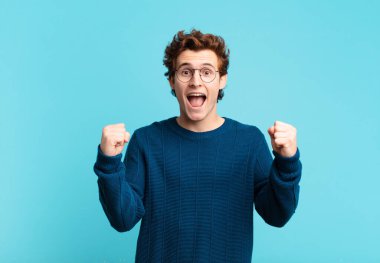 Genç yakışıklı çocuk şokta, heyecanlı ve mutlu, gülüyor ve başarıyı kutluyor,!