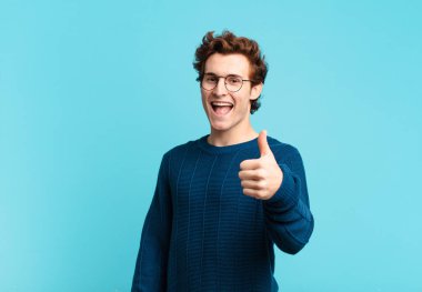 Genç yakışıklı çocuk gururlu, kaygısız, kendinden emin ve mutlu, olumlu gülümsüyor.