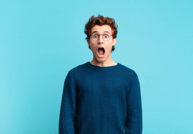 Genç yakışıklı çocuk şok olmuş ya da şaşırmış görünüyor, ağzı açık bir şekilde 