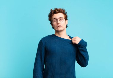 Genç yakışıklı çocuk stresli, endişeli, yorgun ve hayal kırıklığına uğramış, gömleğini çekmiş, sıkıntılı görünüyor.