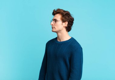 Profil görünümünde genç yakışıklı çocuk ilerideki boşluğu kopyalamaya çalışıyor, düşünüyor, hayal ediyor ya da hayal kuruyor.