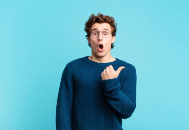 Genç ve yakışıklı bir çocuk inançsızlıktan şaşkın şaşkın bakıyor, yan taraftaki objeyi işaret ediyor ve diyor ki: