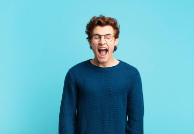 Genç yakışıklı çocuk agresif bir şekilde bağırıyor, çok kızgın, hayal kırıklığına uğramış, öfkeli ya da sinirli görünüyor, hayır