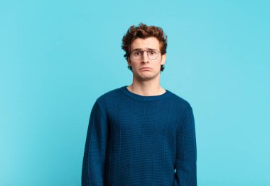 Genç yakışıklı çocuk üzgün ve mızmız, mutsuz bir bakışla, negatif ve hayal kırıklığına uğramış bir tavırla ağlıyor.