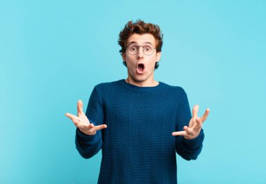 Genç yakışıklı çocuk şok olmuş ve şaşırmış, endişeli ve paniklemiş, stresli ve korkmuş bir bakışla