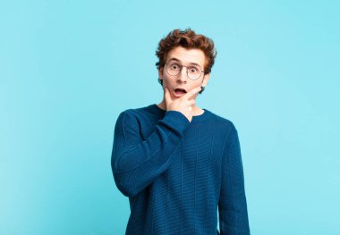 Ağzı ve gözleri açık, eli çenesinde genç ve yakışıklı bir çocuk. Hoş olmayan bir şok geçiriyor. Ne diyor?