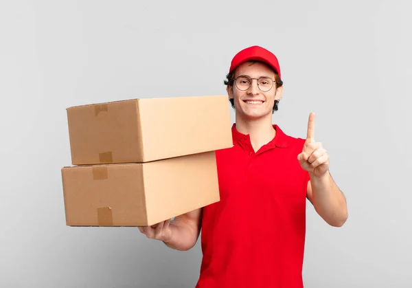 Paquete Entregar Niño Sonriendo Buscando Amigable Mostrando Número Uno Primero — Foto de Stock