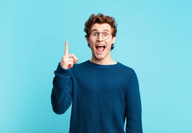 Genç yakışıklı çocuk bir fikri fark ettikten sonra mutlu ve heyecanlı bir dahi gibi hissediyor, neşeli bir şekilde parmağını kaldırıyor, eureka!