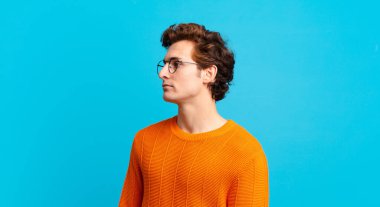 Profil görünümünde genç yakışıklı çocuk ilerideki boşluğu kopyalamaya çalışıyor, düşünüyor, hayal ediyor ya da hayal kuruyor.