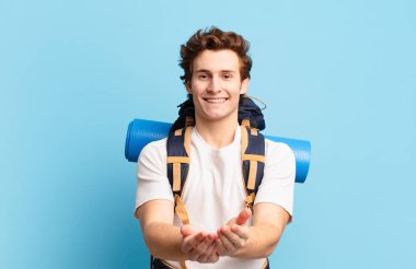 Yürüyüşçü çocuk gülerek güler yüzlü, kendine güvenen, olumlu bakışlı, bir nesne ya da konsept sunan ve gösteren