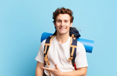 Yürüyüşçü çocuk mutlu bir şekilde gülümsüyor, mutlu hissediyor ve fotokopi uzayında bir konsept gösteriyor.