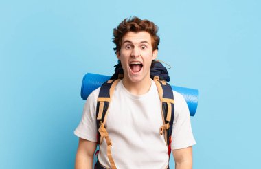 Yürüyüşçü çocuk agresif bir şekilde bağırıyor, sinirli, sinirli, öfkeli ya da sinirli görünüyor.