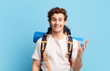 Yürüyüşçü çocuk mutlu, şaşırmış ve neşeli, pozitif bir tavırla gülümsüyor, bir çözüm ya da fikir buluyor.