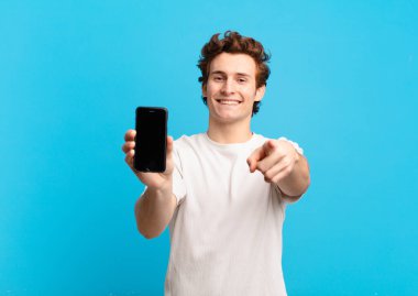 Genç çocuk kameraya tatmin olmuş, kendinden emin, dostane bir gülümsemeyle bakıyor ve seni seçiyor. telefon ekranı kavramı
