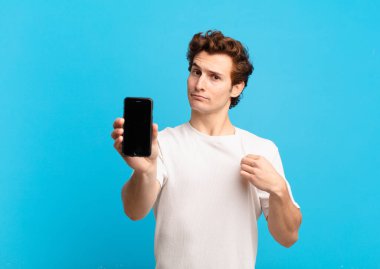 Genç çocuk kibirli, başarılı, pozitif ve gururlu görünüyor, kendini işaret ediyor. telefon ekranı kavramı