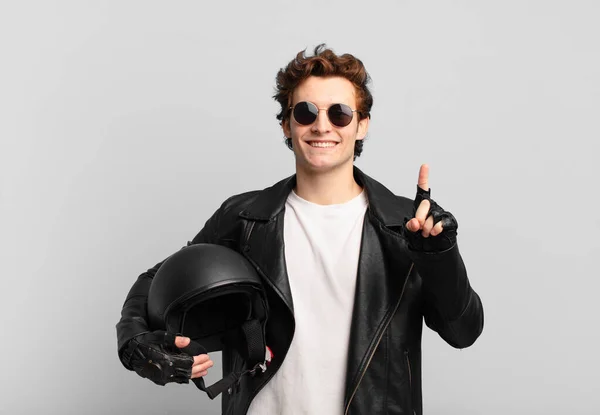 Motociclista Menino Sorrindo Olhando Amigável Mostrando Número Primeiro Com Mão — Fotografia de Stock