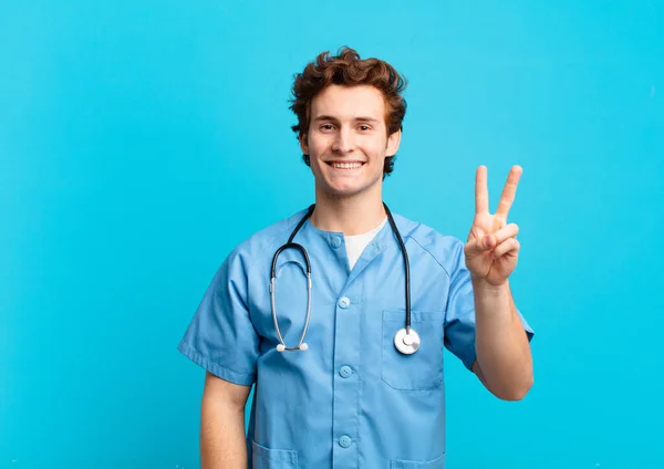 Mladý Ošetřovatel Muž Usmívá Vypadá Přátelsky Ukazuje Číslo Dvě Nebo — Stock fotografie