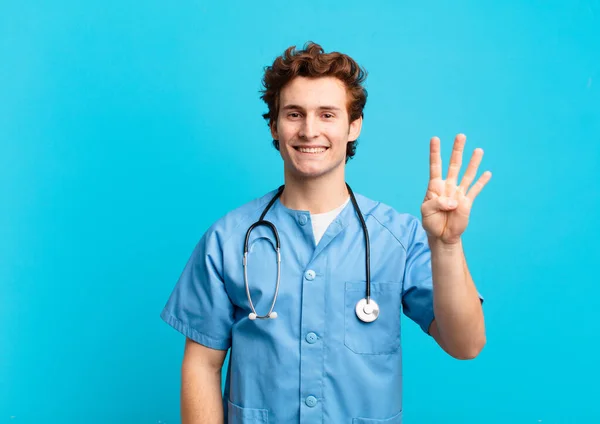 Junger Krankenpfleger Lächelt Und Schaut Freundlich Zeigt Nummer Vier Oder — Stockfoto