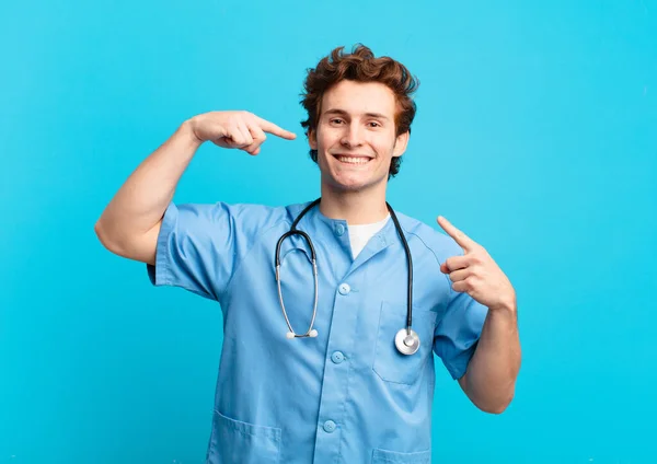 Joven Enfermero Sonriendo Con Confianza Apuntando Propia Amplia Sonrisa Actitud —  Fotos de Stock