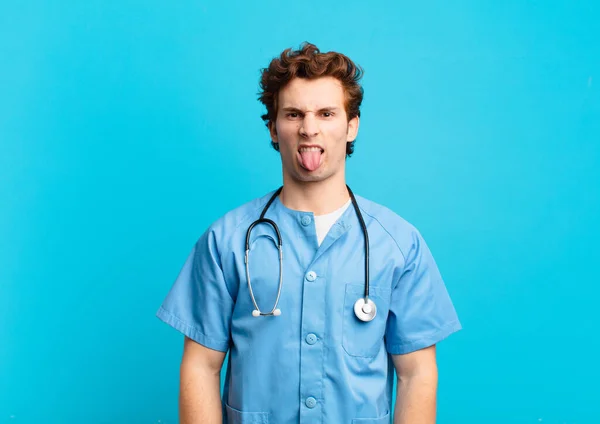 Ung Sjuksköterska Man Känner Äcklad Och Irriterad Sticker Tungan Ogillar — Stockfoto
