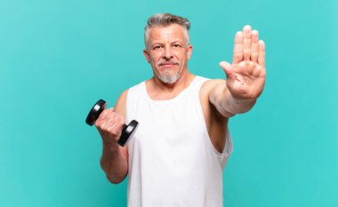 Kıdemli sporcu ciddi, sert, hoşnutsuz ve kızgın görünüyor.