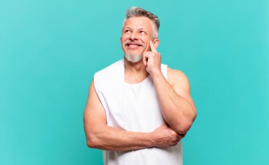 Kıdemli sporcu mutlu bir şekilde gülümsüyor ve hayal kuruyor ya da şüphe ediyor.