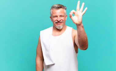 Son sınıf sporcusu mutlu, rahat ve tatmin olmuş hissediyor. İyi bir jestle onaylıyor, gülümsüyor.