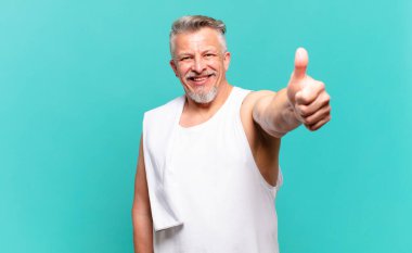 Son sınıf sporcusu gururlu, tasasız, kendinden emin ve mutlu, başparmağıyla olumlu gülümsüyor.