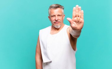 Kıdemli sporcu ciddi, sert, hoşnutsuz ve kızgın görünüyor.