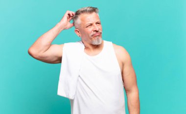 Son sınıf atlet kafası karışmış ve kafası karışmış hissediyor, başını kaşıyor ve yan tarafa bakıyor.