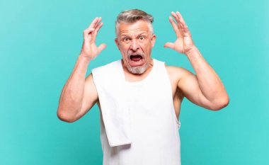 Kıdemli sporcu elleri havada bağırıyor. Öfkeli, sinirli, stresli ve üzgün.