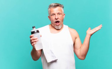 Son sınıf atlet şaşırmış ve şoka uğramış görünüyor. Çenesi düşmüş ve eli açık bir obje tutuyor.