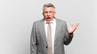 kıdemli işadamı mutlu, şaşırmış ve neşeli hissediyor, olumlu bir tavırla gülümsüyor, bir çözüm ya da fikri fark ediyor.