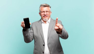 Kıdemli iş adamı gülümsüyor ve arkadaş canlısı görünüyor. Bir numara ya da ilk eli önde, geriye doğru sayıyor.