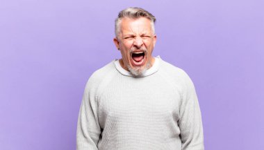 old senior man shouting aggressively, looking very angry, frustrated, outraged or annoyed, screaming no