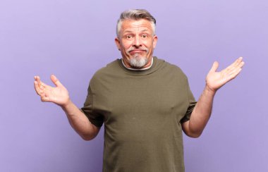 old senior man feeling puzzled and confused, doubting, weighting or choosing different options with funny expression