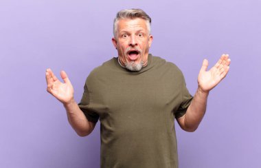 old senior man feeling happy, excited, surprised or shocked, smiling and astonished at something unbelievable