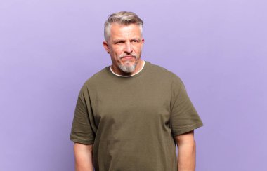 old senior man feeling sad, upset or angry and looking to the side with a negative attitude, frowning in disagreement