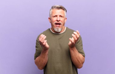 old senior man looking desperate and frustrated, stressed, unhappy and annoyed, shouting and screaming
